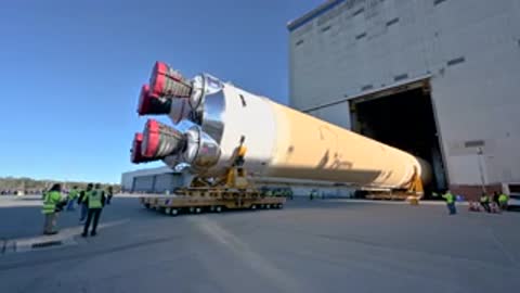 Large rocket stage being transported out of manufacturing building