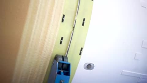Close-up of a tool running along a seam on a rocket component.