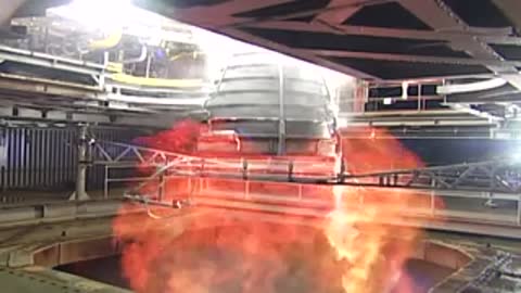 Rocket engine test firing inside a structural testing facility.
