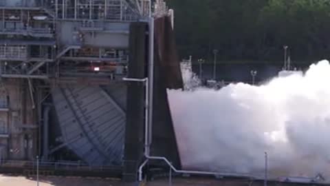 Close exterior view of massive white smoke billowing from test stand.