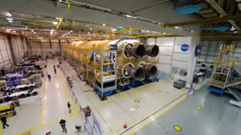 High-angle view of rocket core stage with four engines inside large facility.