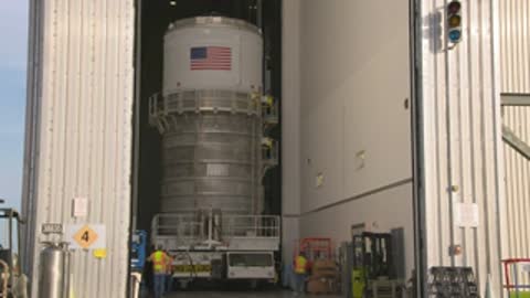medium shot of large rocket component inside assembly building