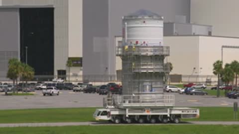 medium shot of transport vehicle with rocket segment near parking lot