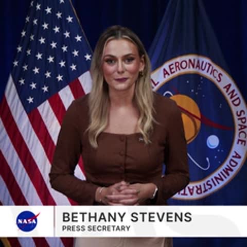 Bethany Stevens, press secretary, speaking in front of US and NASA flags.