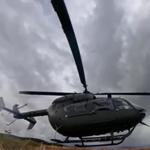 Helicopter taking off and landing on a rocky mountain ridge.