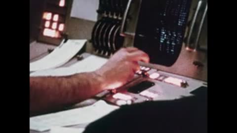 Close-up of a hand operating controls and switches on a console panel