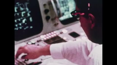 Close-up of an operator pressing buttons on a complex control panel