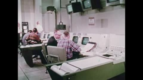 engineers collaborating around console in control room