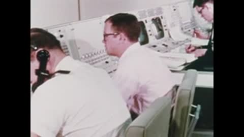 engineer wearing headset working at computer console in room