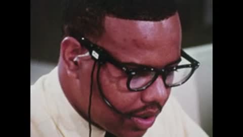 close-up of person wearing glasses and headset in control room