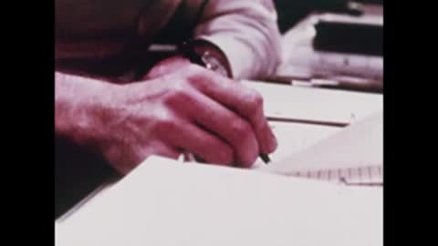 A close-up of a person's hands writing notes on paper with a pen.