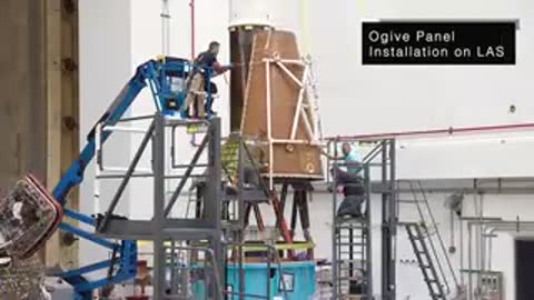 Technicians installing Ogive Panel on Launch Abort System using scaffolding and lift
