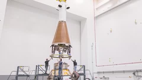 Crane lowering structural element onto Launch Abort System assembly in facility