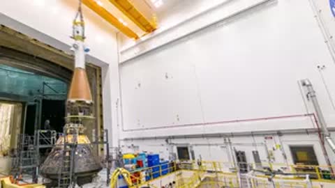 Orion vehicle and test stand visible inside the industrial testing facility.