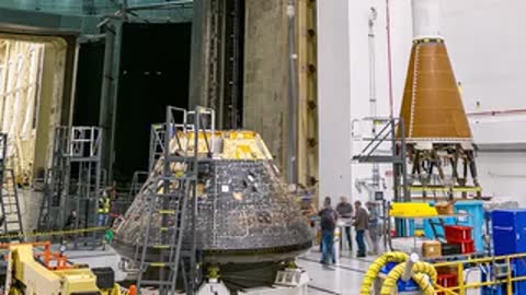 Ground level view of engineers gathered around the Orion crew module.
