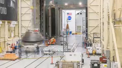 Orion vehicle hoisted by crane inside the high-bay integration facility.