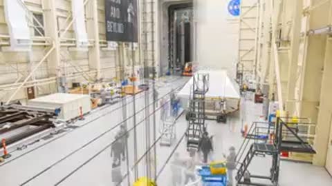 Wide shot of empty factory floor inside large hangar with large open doors