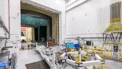 Medium shot of technicians in assembly facility handling metal framework structure