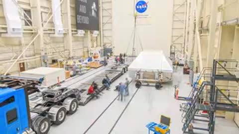 Wide shot of forklift moving large white crate container inside large warehouse