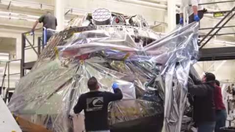 Crew Module being moved and positioned inside clean room facility by team