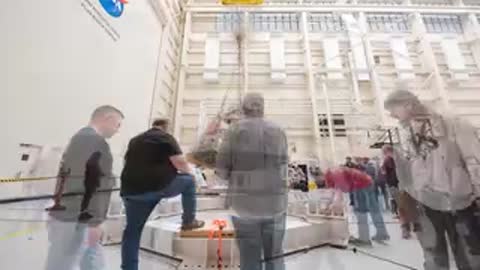 Orion crew module being lifted and positioned onto base platform by crane