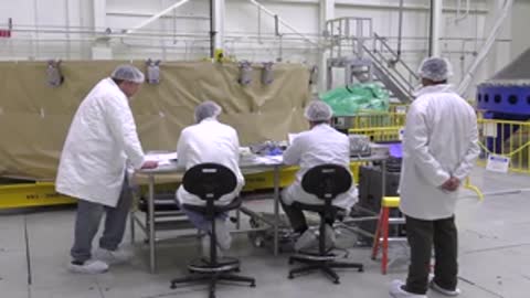 Engineers standing and sitting around a table in a workspace interior.
