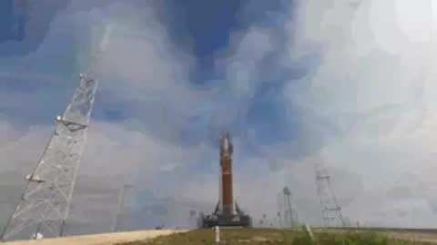 Dawn shot of SLS on launch pad surrounded by rising mist or vapor.