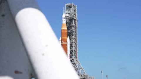Close-up view of rocket section from behind large metal structure.