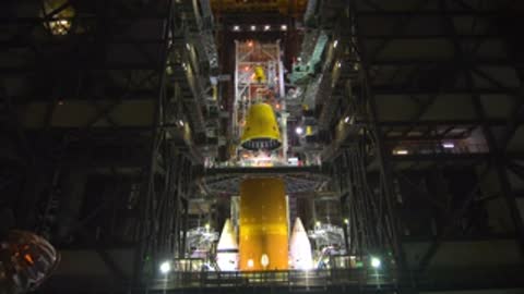 Overhead view of the adapter being lowered toward the top of the central rocket stack.
