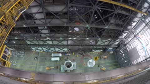 Top-down view of the ICPS stage being lowered precisely into a circular opening on the platform.