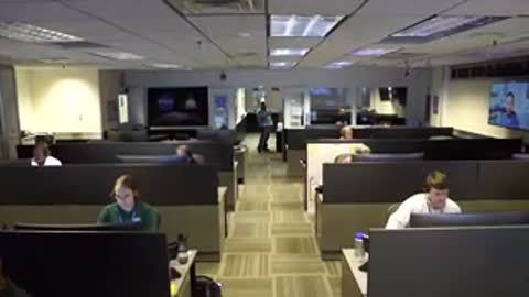 A wide shot of a busy control room with multiple operators at work.