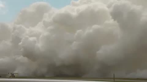 Exterior wide shot of dense white exhaust clouds completely blanketing the area.