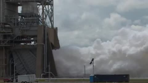 Exterior view of thick white steam pouring out of the engine test bay.