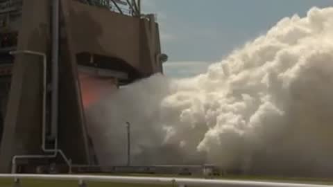 Exterior shot of white exhaust clouds rolling out from the test facility.