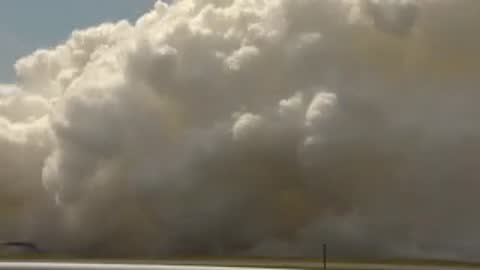 Exterior wide view of dense white smoke billowing across the testing ground.