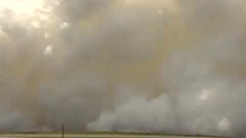 Exterior wide shot showing heavy smoke clouds obscuring the test area.