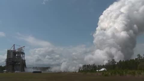 Exterior view of the test stand with a diminishing white smoke plume.