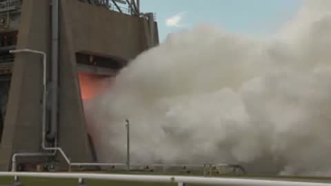 Exterior view of the test facility emitting massive clouds of white steam and exhaust.