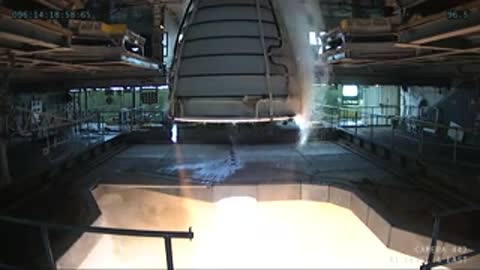 Interior view looking up at the RS-25 engine nozzle actively firing.