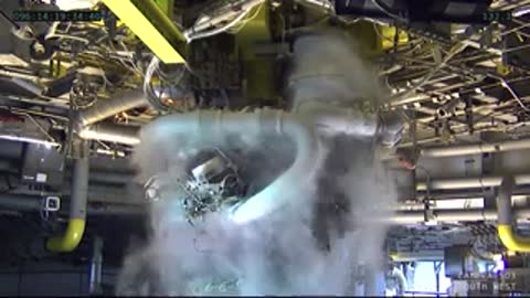 Close-up machinery view of the RS-25 engine operating with vapor swirling.