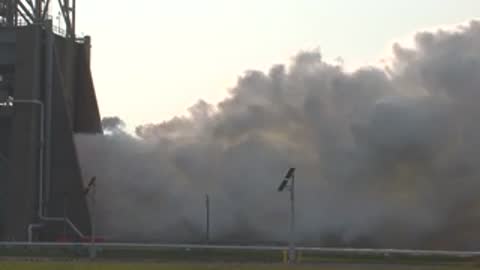Medium side view of smoke billowing from the test stand structure.