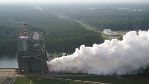 Wide view of the rocket test facility with billowing white exhaust.