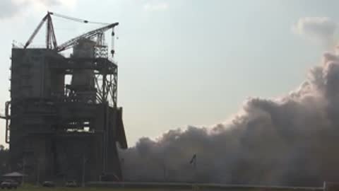 Medium view of smoke rising from the test facility area.