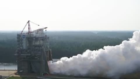 Wide view of white exhaust smoke streaming across the landscape.