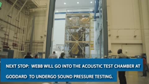 wide view of workers and the covered telescope in the assembly facility