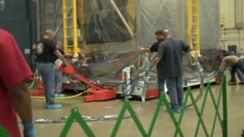 medium shot of workers moving the telescope tent in the facility