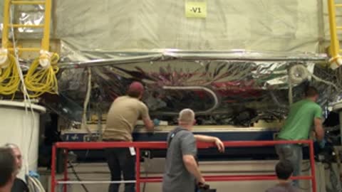 medium shot of technicians working near the base of the telescope structure