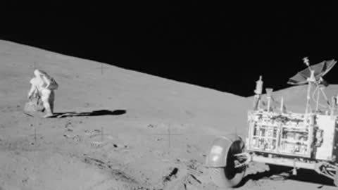 Archival footage of an astronaut working near a lunar rover on the surface.