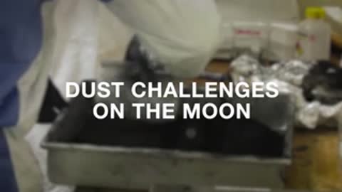 People in lab coats pour dark material from a container onto a table.