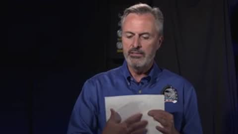 Man reading paper, studio setting.